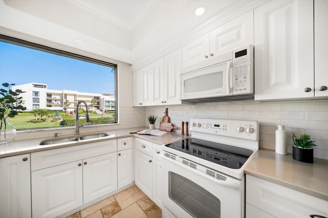 kitchen featuring white appliances, light countertops, a sink, and white cabinetry