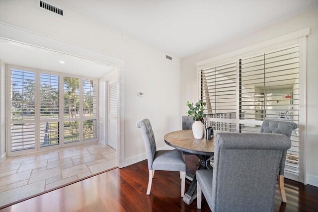 dining area featuring baseboards, visible vents, and wood finished floors