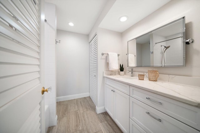 full bath featuring recessed lighting, wood finished floors, vanity, baseboards, and a closet