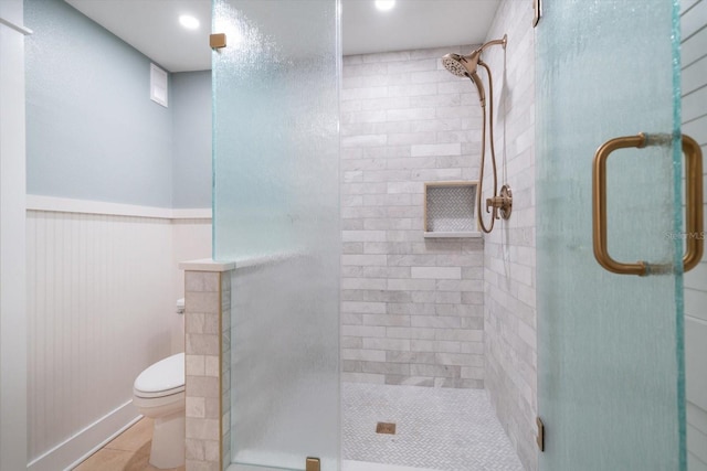 bathroom with toilet, a stall shower, and tile patterned floors