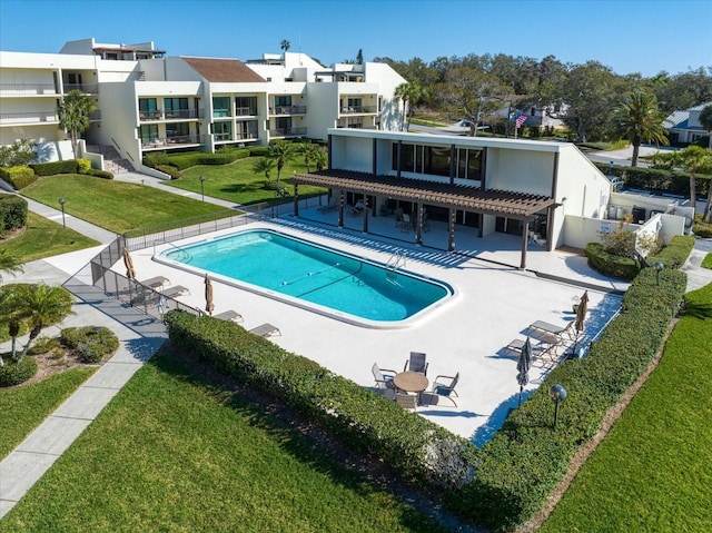 community pool featuring a patio area, a lawn, fence, and a pergola