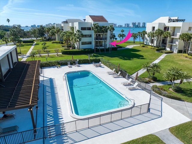 community pool with a yard, a patio area, and fence