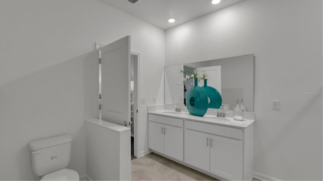 full bathroom featuring recessed lighting, a sink, toilet, and double vanity