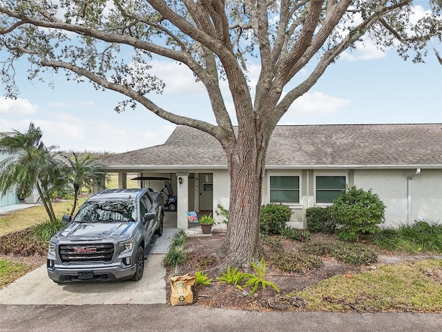 view of front of home with driveway, a shingled roof, and stucco siding