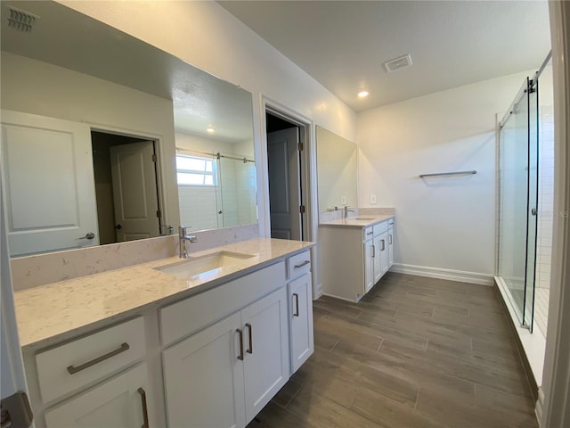 full bath featuring a sink, visible vents, wood finish floors, and a shower stall