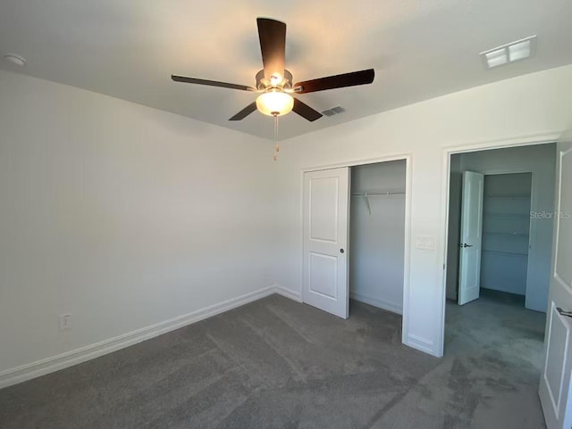 unfurnished bedroom with visible vents, baseboards, and dark carpet