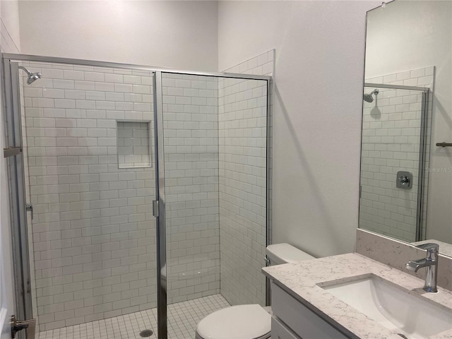 full bathroom with a stall shower, toilet, and vanity