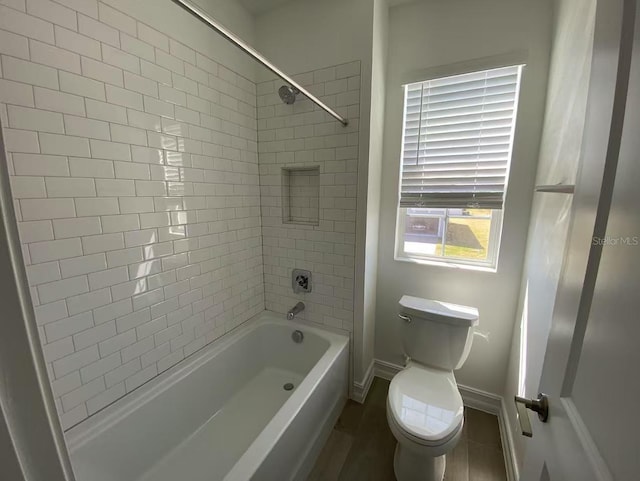 full bath with shower / washtub combination, toilet, and baseboards