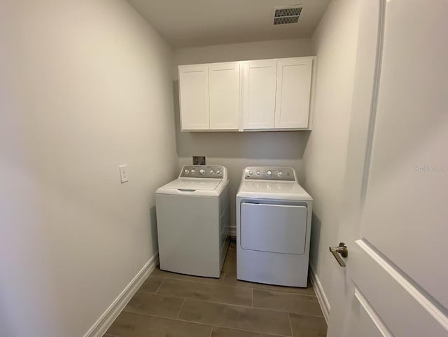 laundry area with baseboards, cabinet space, visible vents, and washer and clothes dryer