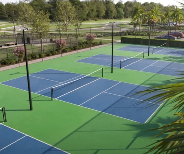 view of tennis court featuring community basketball court and fence