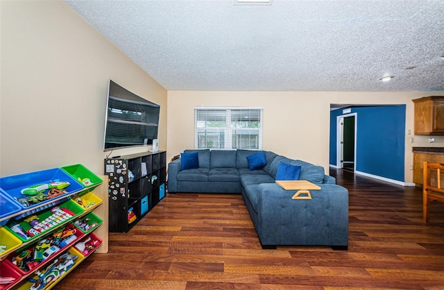 living room featuring a textured ceiling, wood finished floors, and baseboards