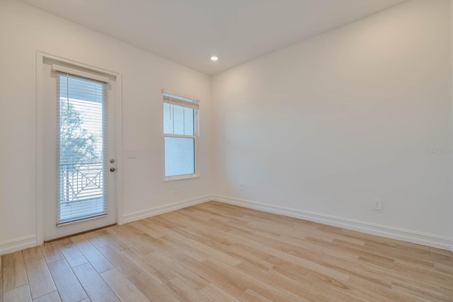 spare room with light wood finished floors, baseboards, and recessed lighting