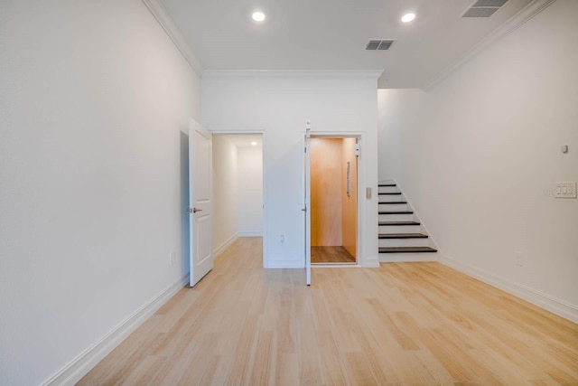 unfurnished room with baseboards, visible vents, light wood-style flooring, and crown molding