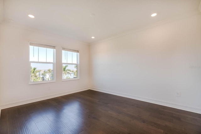 spare room with dark wood-style floors, baseboards, crown molding, and recessed lighting