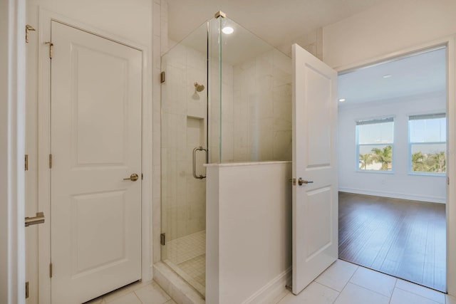 bathroom featuring a shower stall, baseboards, and tile patterned floors