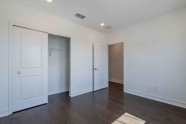 unfurnished bedroom featuring baseboards, visible vents, dark wood-style floors, a closet, and recessed lighting