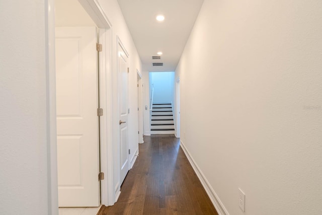 hallway with stairs, recessed lighting, baseboards, and wood finished floors