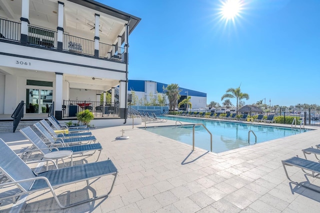 community pool with a patio and fence