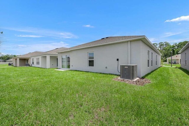 1931 Rosewood Cir, Lakeland, FL 33810 - rear view of house with stucco siding, a lawn, and roof with shingles