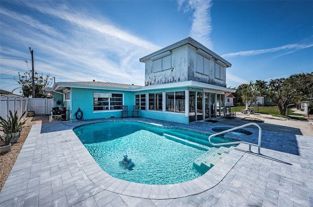 rear view of house with a fenced in pool, a sunroom, fence, a patio area, and stucco siding