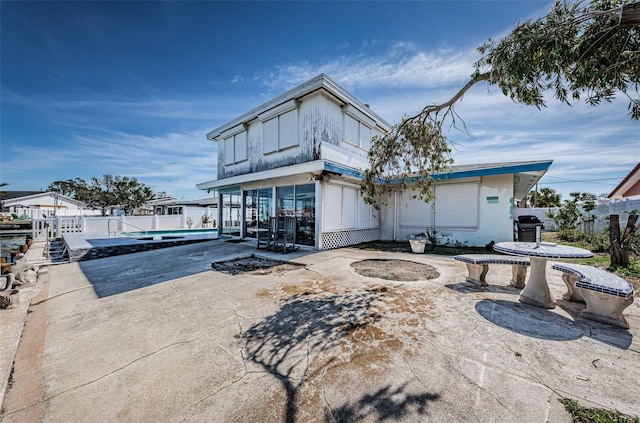 rear view of property featuring a patio area and fence