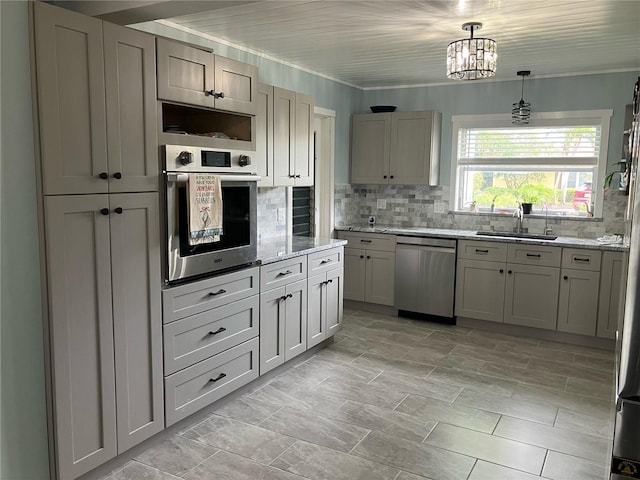 629 59th Ave, St Pete Beach, FL 33706 - kitchen featuring light stone counters, a sink, stainless steel appliances, decorative light fixtures, and tasteful backsplash