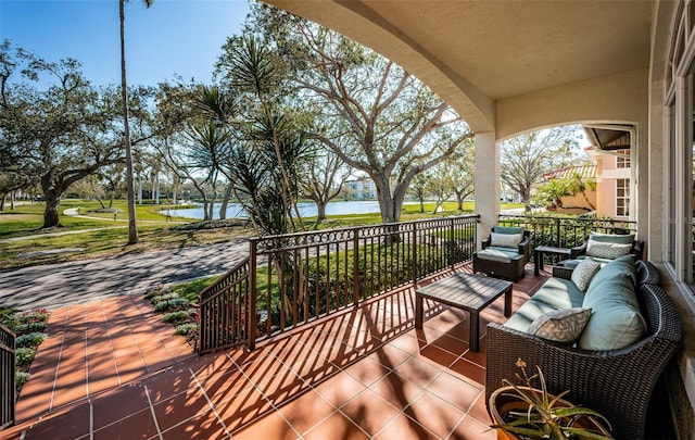 balcony with an outdoor hangout area and a water view