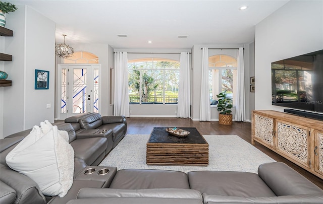 living area featuring a notable chandelier, baseboards, wood finished floors, and recessed lighting