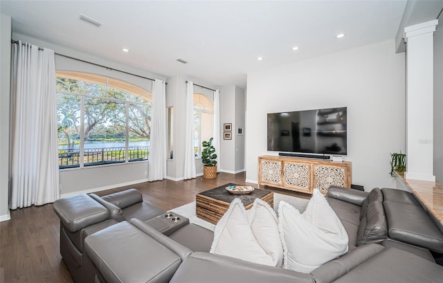 living room featuring baseboards, visible vents, wood finished floors, and recessed lighting