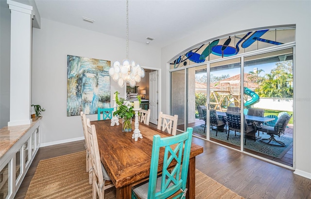 dining area featuring visible vents, dark wood finished floors, baseboards, and an inviting chandelier