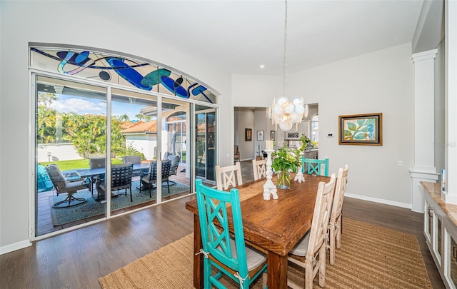 dining room with a chandelier, baseboards, and dark wood-style floors