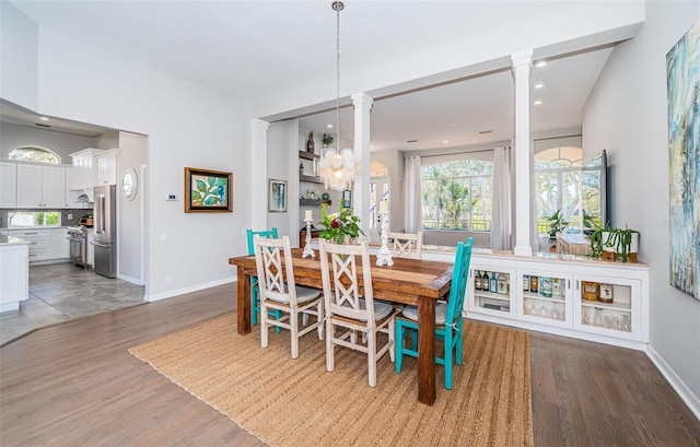 dining area with an inviting chandelier, baseboards, wood finished floors, and recessed lighting