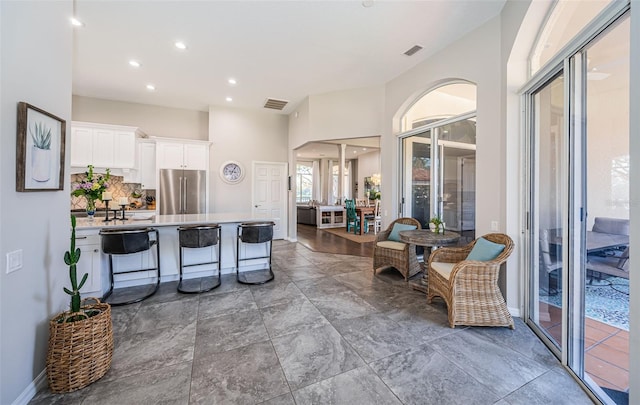 kitchen featuring light countertops, high end refrigerator, visible vents, and white cabinets