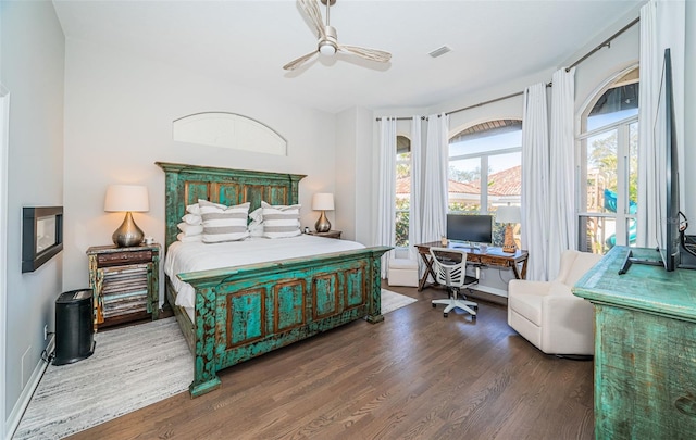 bedroom featuring ceiling fan, wood finished floors, visible vents, and baseboards