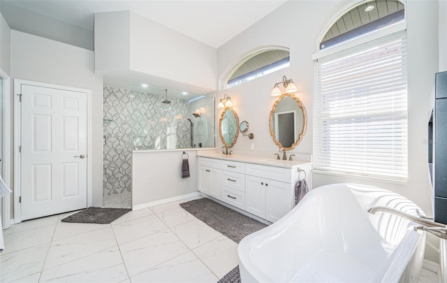 full bathroom featuring a sink, a freestanding bath, marble finish floor, double vanity, and walk in shower