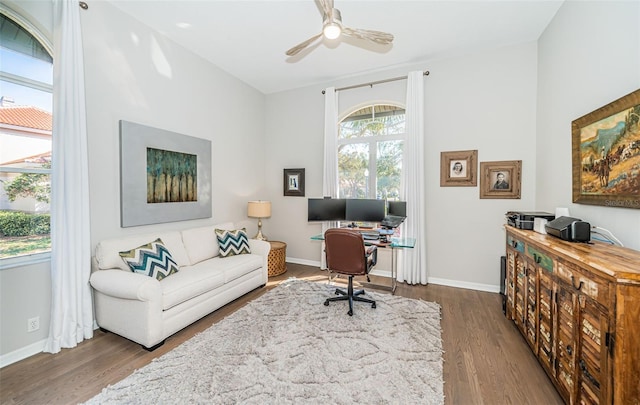 home office with a ceiling fan, baseboards, and wood finished floors