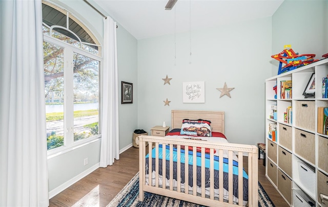 bedroom featuring ceiling fan, wood finished floors, and baseboards