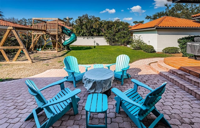 view of patio / terrace with fence and a playground