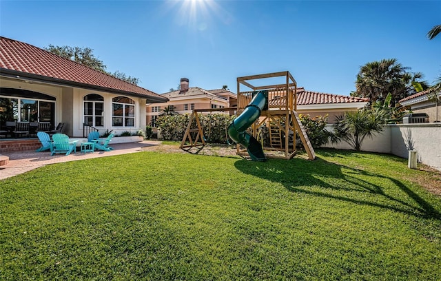 view of yard featuring a playground, a patio, and a fenced backyard