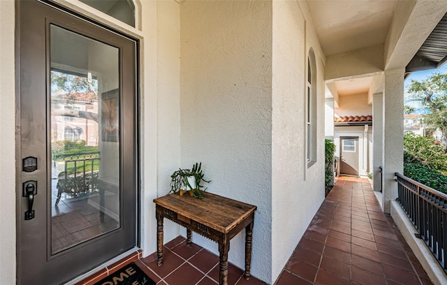 property entrance with a balcony and stucco siding