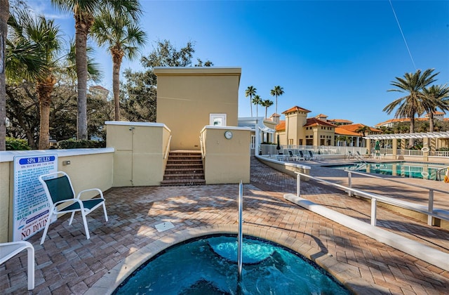 community pool featuring a patio area and a hot tub