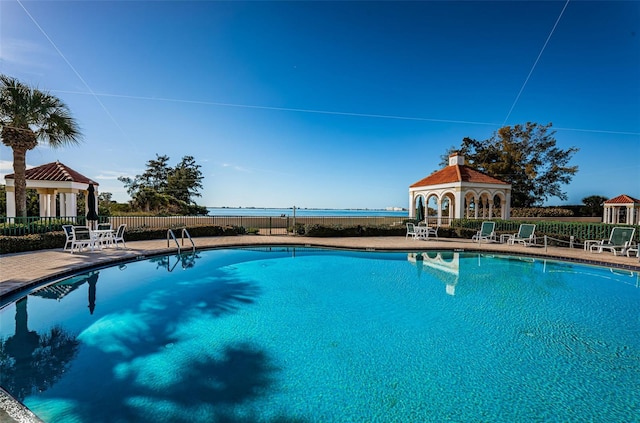 pool with a patio area, fence, and a gazebo