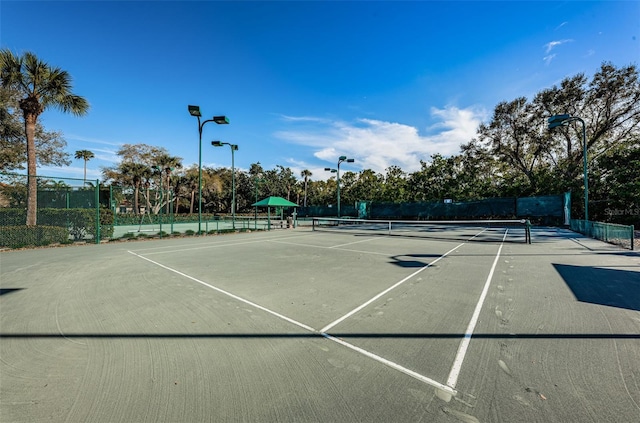 view of tennis court featuring fence