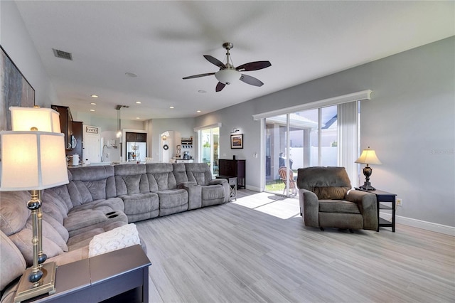 living area featuring visible vents, light wood-style flooring, a ceiling fan, recessed lighting, and baseboards