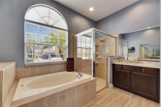 bathroom featuring vanity, a garden tub, wood finished floors, and a stall shower