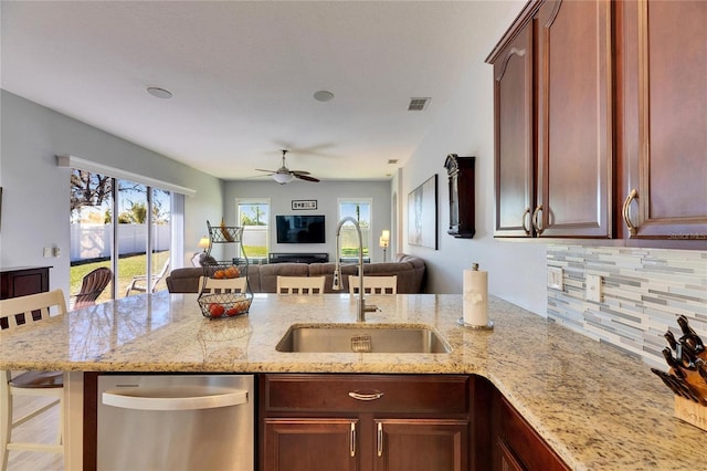 kitchen featuring visible vents, a sink, open floor plan, a wealth of natural light, and stainless steel dishwasher