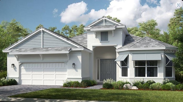 view of front of house with a garage, a front yard, decorative driveway, and stucco siding