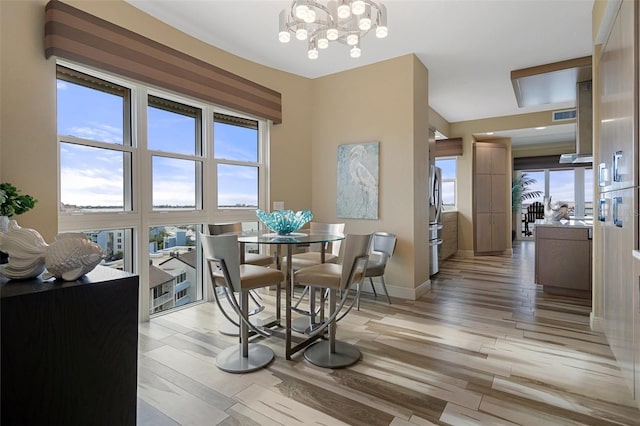 4951 Bacopa Ln S Unit 801, Saint Petersburg, FL 33715 - dining space featuring visible vents, light wood-style flooring, an inviting chandelier, and baseboards