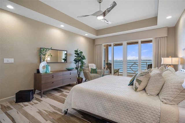 4951 Bacopa Ln S Unit 801, Saint Petersburg, FL 33715 - bedroom with wood finished floors, baseboards, ceiling fan, access to exterior, and a raised ceiling
