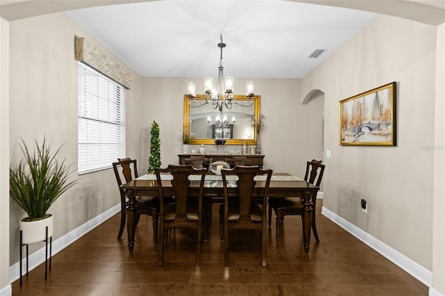 dining space with arched walkways, visible vents, dark wood finished floors, and baseboards